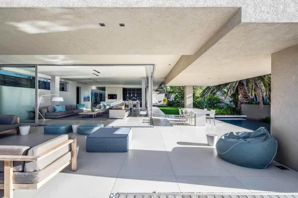 Because this room's architecture follows the low-ceiling trend, the homeowner chose ottoman couches and lazy chairs that are both comfortable and easy to move. Since blue is a cool color, it can be difficult to balance a blue couch with a warm look. This living room managed to look cozy instead of cold due to the open space with the direction of sunlight coming in, combined with the background color tone neutral. For more connectivity and flexibility, try combining colors and types of blue couch in your living space.