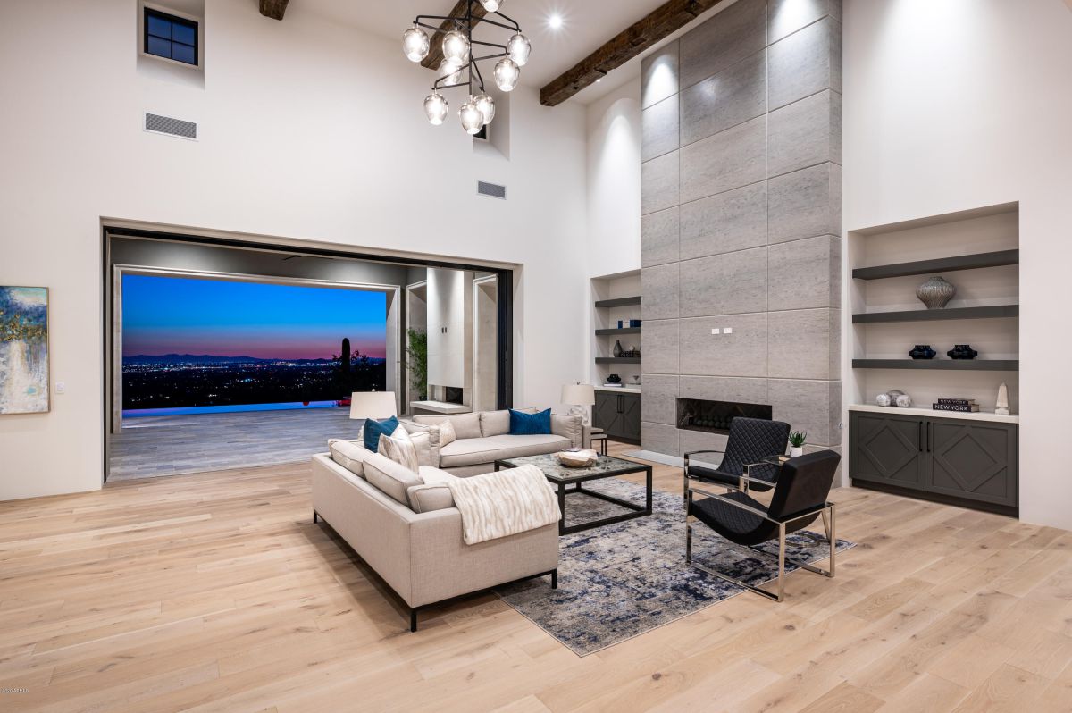 The built-in process is made more easier by floating shelves. No matter how tall or how wide a piece of wood is, it may be chopped to fit a number of spaces. This living room is a modern fantasy with its gray-painted brick fireplace, oak floating shelves, and dark grey lower cupboards.