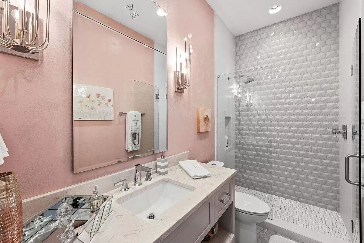 Try a two-tone treatment on the wall behind the sink for a low-cost bathroom backsplash design. This gives the appearance of a backsplash without the expense of tile installation. A soft pink paint tone that complements the slate floor tiles runs partway up the wall in this bathroom to create a feeling of architecture