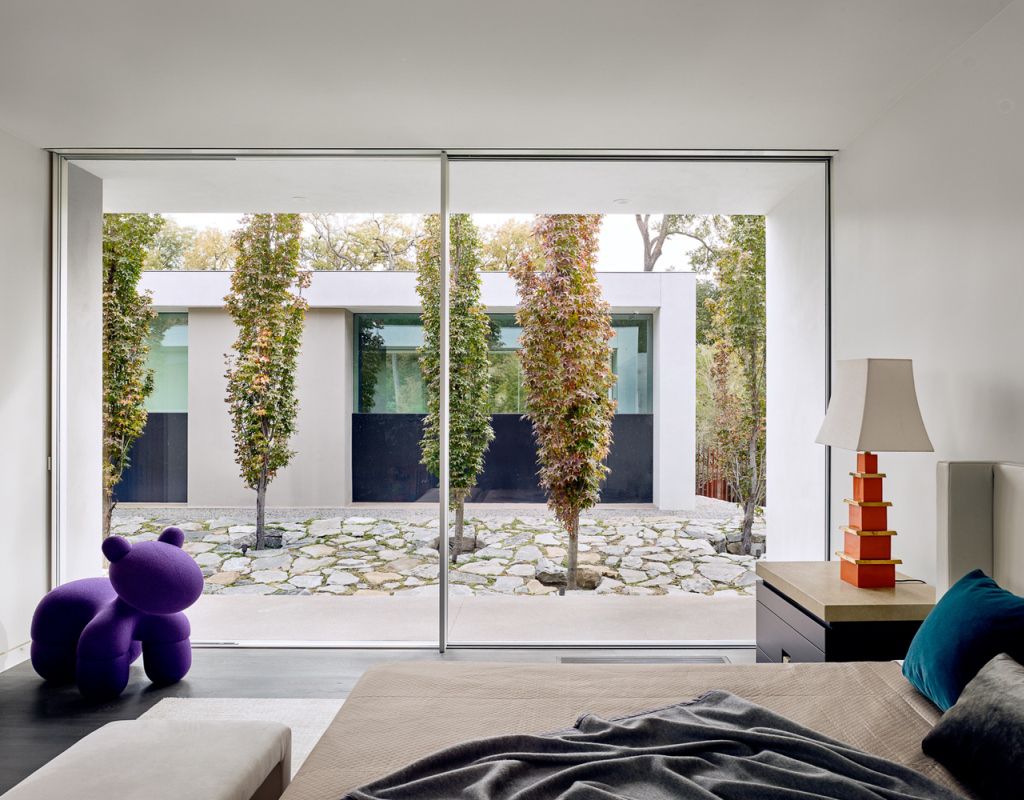 Preston Hollow Home in Dallas was designed by Specht Architects in Modern style from steel columns, frameless windows, and flowing water; this house providing a sense of privacy and seclusion from the street and surrounding neighborhood.