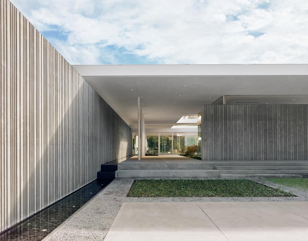 Preston Hollow Home in Dallas was designed by Specht Architects in Modern style from steel columns, frameless windows, and flowing water; this house providing a sense of privacy and seclusion from the street and surrounding neighborhood.