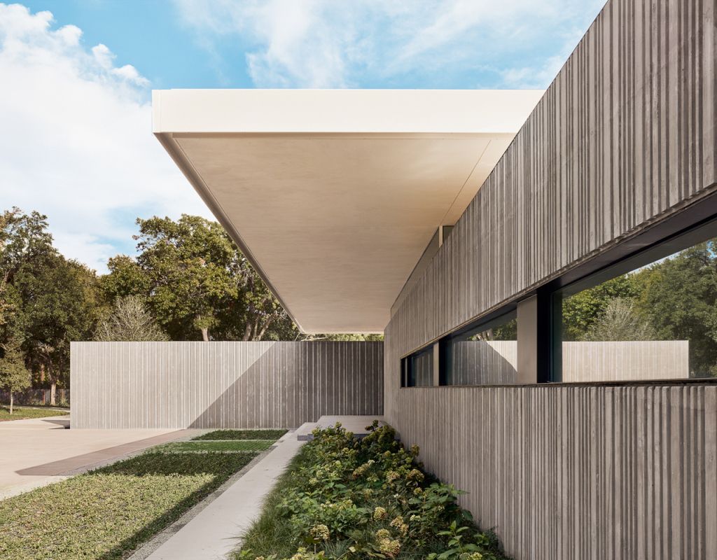 Preston Hollow Home in Dallas was designed by Specht Architects in Modern style from steel columns, frameless windows, and flowing water; this house providing a sense of privacy and seclusion from the street and surrounding neighborhood.