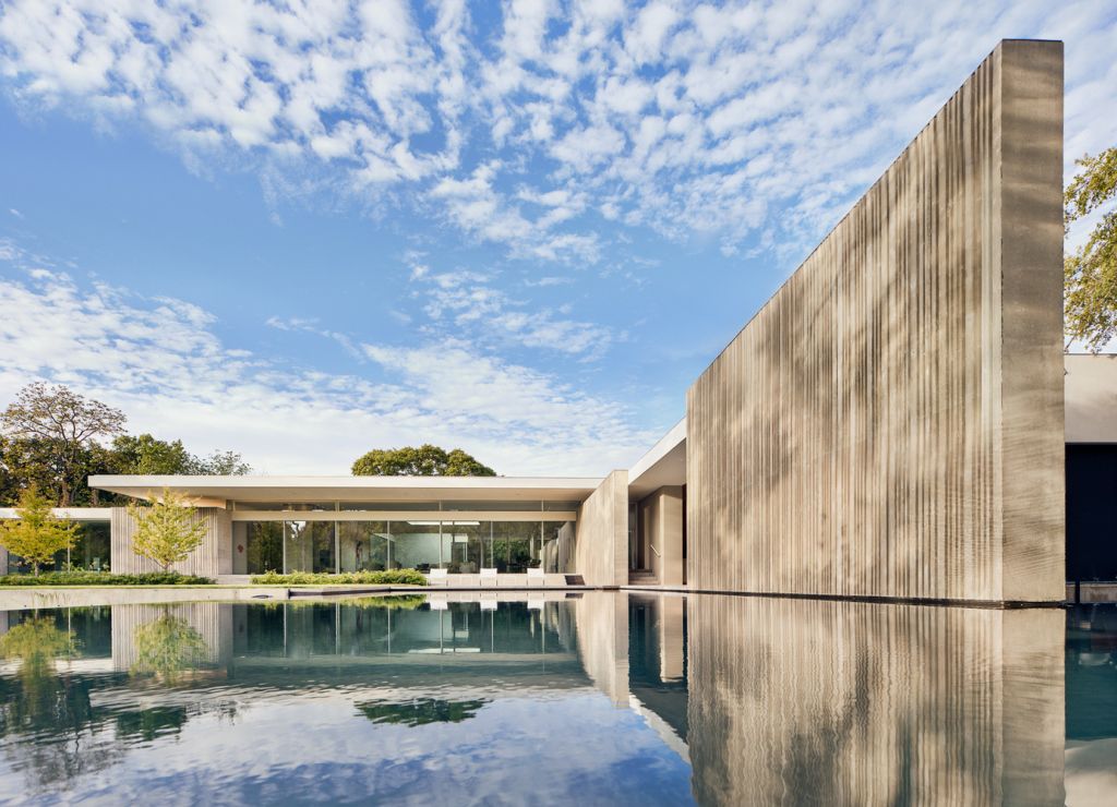 Preston Hollow Home in Dallas was designed by Specht Architects in Modern style from steel columns, frameless windows, and flowing water; this house providing a sense of privacy and seclusion from the street and surrounding neighborhood.