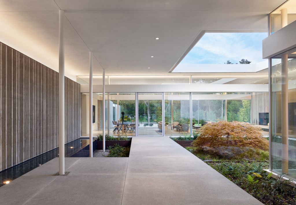 Preston Hollow Home in Dallas was designed by Specht Architects in Modern style from steel columns, frameless windows, and flowing water; this house providing a sense of privacy and seclusion from the street and surrounding neighborhood.