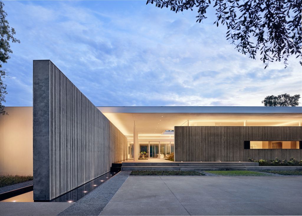 Preston Hollow Home in Dallas was designed by Specht Architects in Modern style from steel columns, frameless windows, and flowing water; this house providing a sense of privacy and seclusion from the street and surrounding neighborhood.