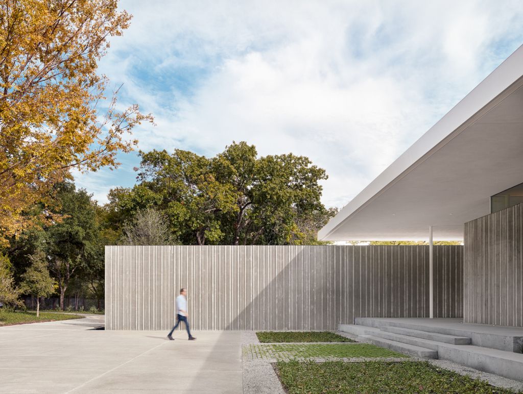 Preston Hollow Home in Dallas was designed by Specht Architects in Modern style from steel columns, frameless windows, and flowing water; this house providing a sense of privacy and seclusion from the street and surrounding neighborhood.