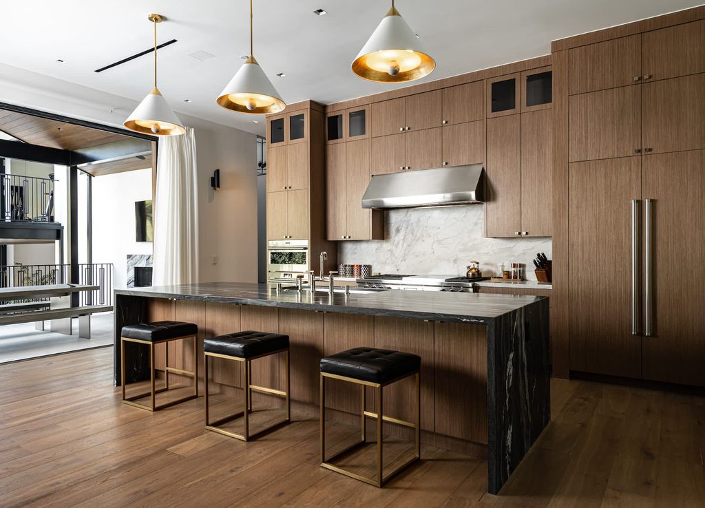 Here's a kitchen sink design worth considering, especially if you have a wide island with adequate seats. There's so much to inspire you, from the wooden seats to the vintage-style pendant hanging lamps. The gold rustic faucet adds a 'period' logical sense without making it appear out of date.