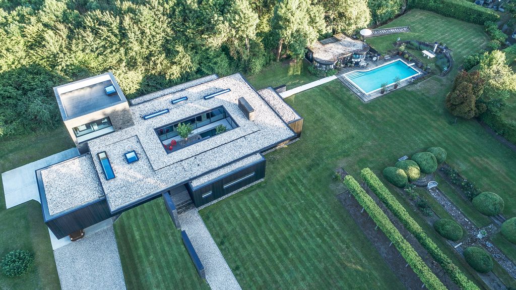 Black House in United Kingdom designed by AR Design Studio in Modern style; this house offers linear views across four carefully sculpted gardens. This home located on beautiful lot with amazing views and wonderful outdoor living spaces including patio, pool, garden.