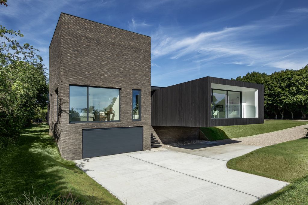 Black House in United Kingdom designed by AR Design Studio in Modern style; this house offers linear views across four carefully sculpted gardens. This home located on beautiful lot with amazing views and wonderful outdoor living spaces including patio, pool, garden.