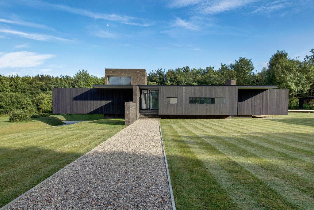 Black House in United Kingdom designed by AR Design Studio in Modern style; this house offers linear views across four carefully sculpted gardens. This home located on beautiful lot with amazing views and wonderful outdoor living spaces including patio, pool, garden.