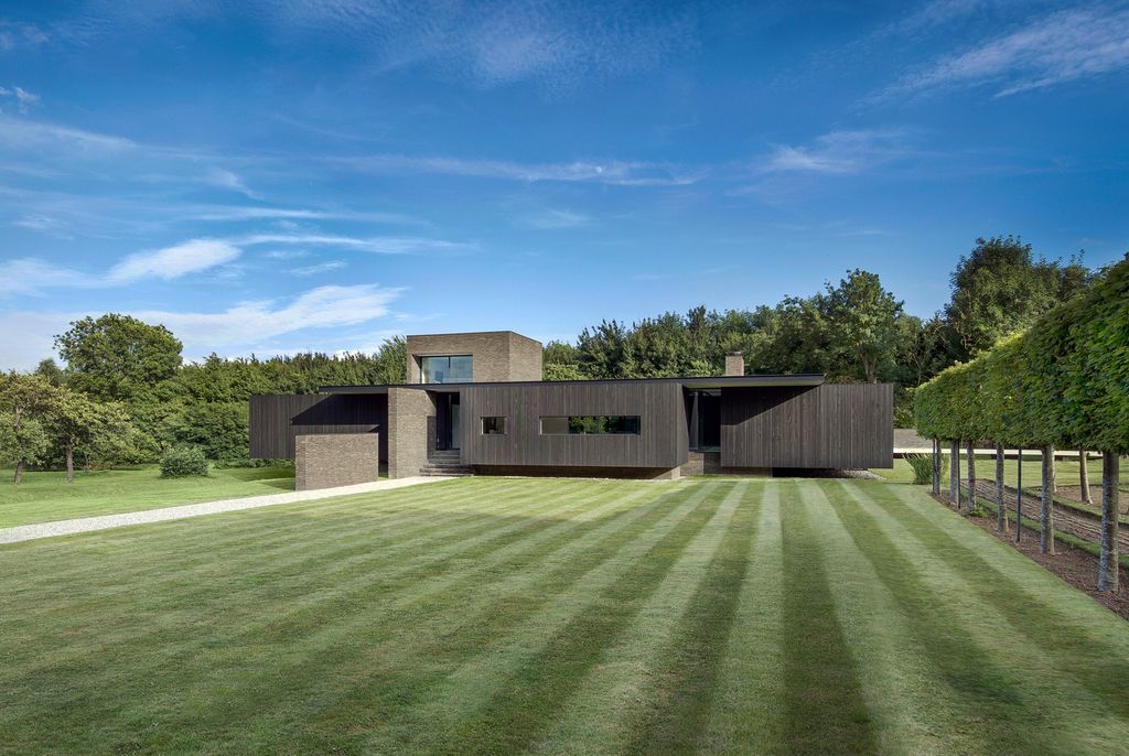 Black House in United Kingdom designed by AR Design Studio in Modern style; this house offers linear views across four carefully sculpted gardens. This home located on beautiful lot with amazing views and wonderful outdoor living spaces including patio, pool, garden.