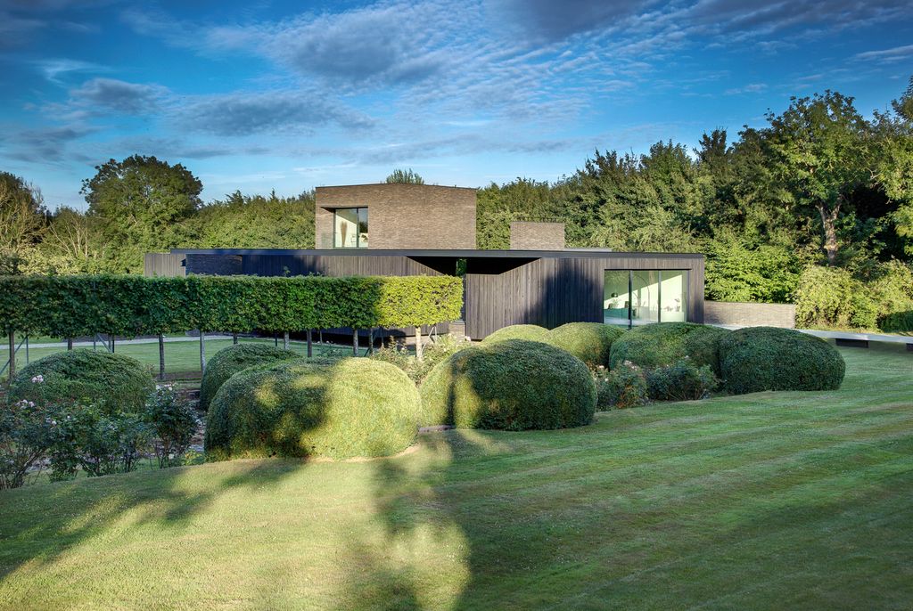 Black House in United Kingdom designed by AR Design Studio in Modern style; this house offers linear views across four carefully sculpted gardens. This home located on beautiful lot with amazing views and wonderful outdoor living spaces including patio, pool, garden.