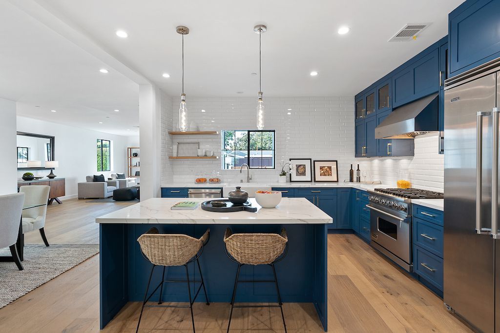 Install durable and high-quality hanging wooden shelves like the ones shown here if you have spare space over your kitchen sink. The cutlery is readily available, and the room does not look 'bare.'You may also store cleaning and laundry materials, putting everything within easy reach.