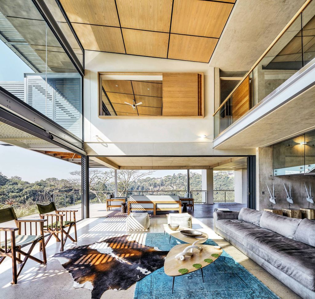 idyllic, rural, and cool the tranquil hues of blue, the charming rusticness of wood, and the contemporary vibe of the white, spotless walls and wood floors. The exposed wood beams emphasize the elegance of the area, while the sofa and chair combination keeps things intriguing.