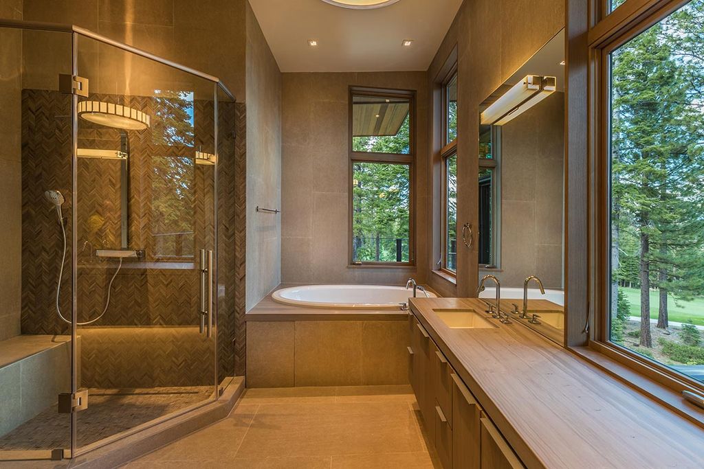 Modern bathrooms do not have to be frigid and antiseptic. We're sticking with geometrical shapes (in this example, egg-like shapes via the sink and tub), a basic color palette (warm neutrals), and minimum ornamental items. Wood and stone (or realistic imitations) are common contemporary characteristics. This one has more decoration than most modern bathrooms, but the decorations are simple and in basic shapes: empty frames, paddles, and candles.