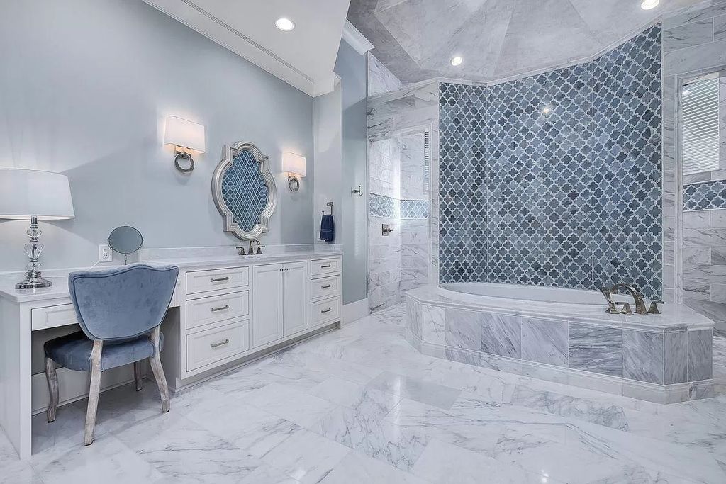 For a clutter-free bathroom design with a relaxing flash of color, the light blue backsplash surrounds a contemporary vessel sink and wall-mounted faucets. The tile backsplash's gleaming surface nicely reflects light from the ceiling above. 