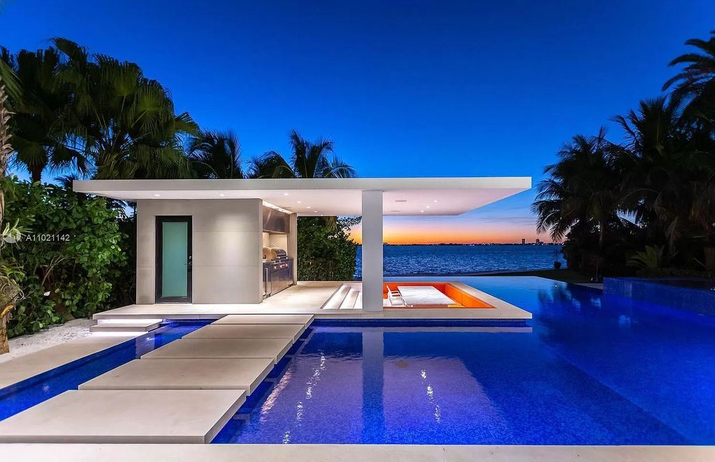 The Resort Style Mansion in Miami Beach is a newly luxurious home with sunsets over the Miami skyline on prestigious North bay road now available for sale. This home located at 5004 N Bay Rd, Miami Beach, Florida; offering 8 bedrooms and 10 bathrooms with over 12,800 square feet of living spaces. 