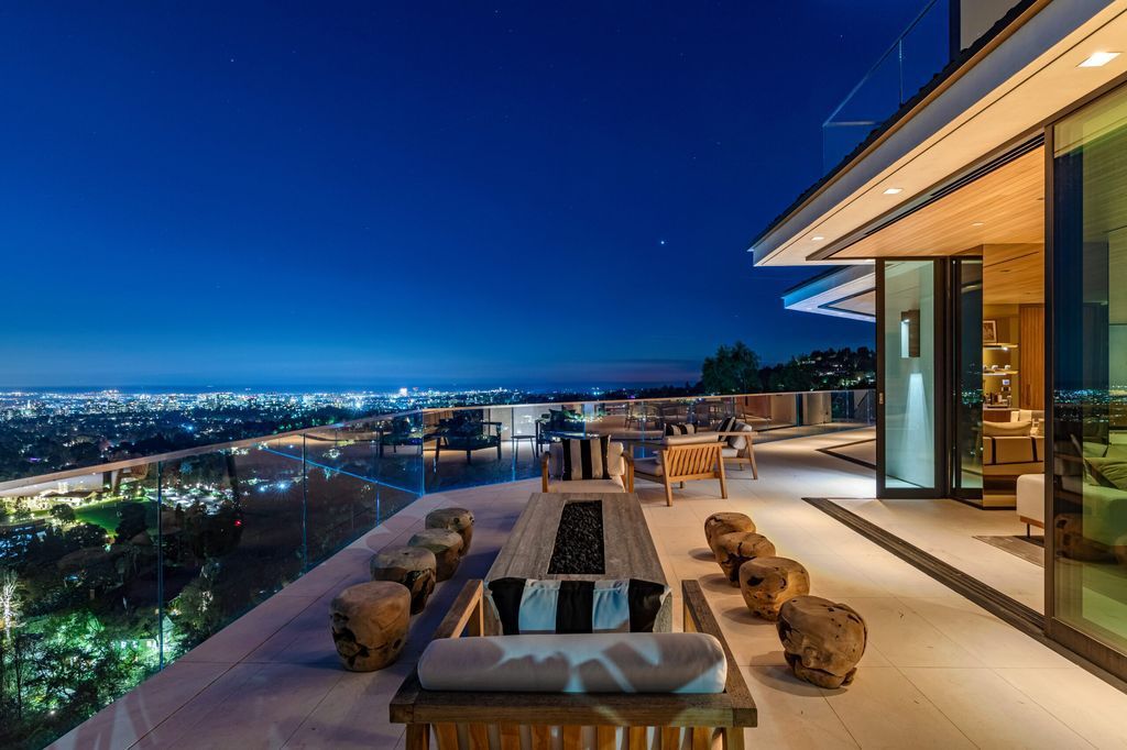The Beverly Hills Mansion is a warm organic modern estate on one of the best promontories in Beverly Hills with unobstructed views now available for sale. This home located at 10102 Angelo View Dr, Beverly Hills, California; offering 4 bedrooms and 6 bathrooms with over 7,000 square feet of living spaces. 