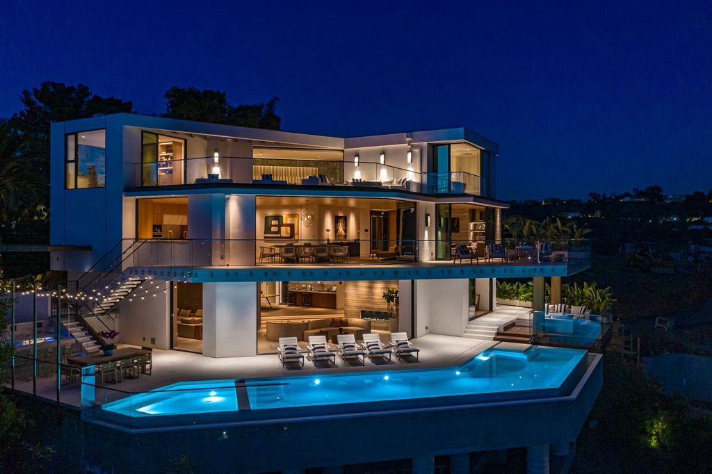 The Beverly Hills Mansion is a warm organic modern estate on one of the best promontories in Beverly Hills with unobstructed views now available for sale. This home located at 10102 Angelo View Dr, Beverly Hills, California; offering 4 bedrooms and 6 bathrooms with over 7,000 square feet of living spaces. 