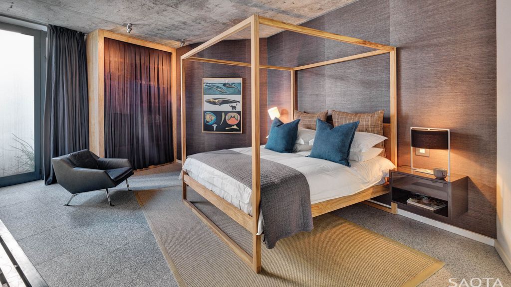 Anchor the space with a four-poster bed for the most inviting atmosphere. If you don't like frills or curtains, choose a simplified design with straight poles and no crossbeams or fabric. Always choose a big scale; it should take up most of the space.