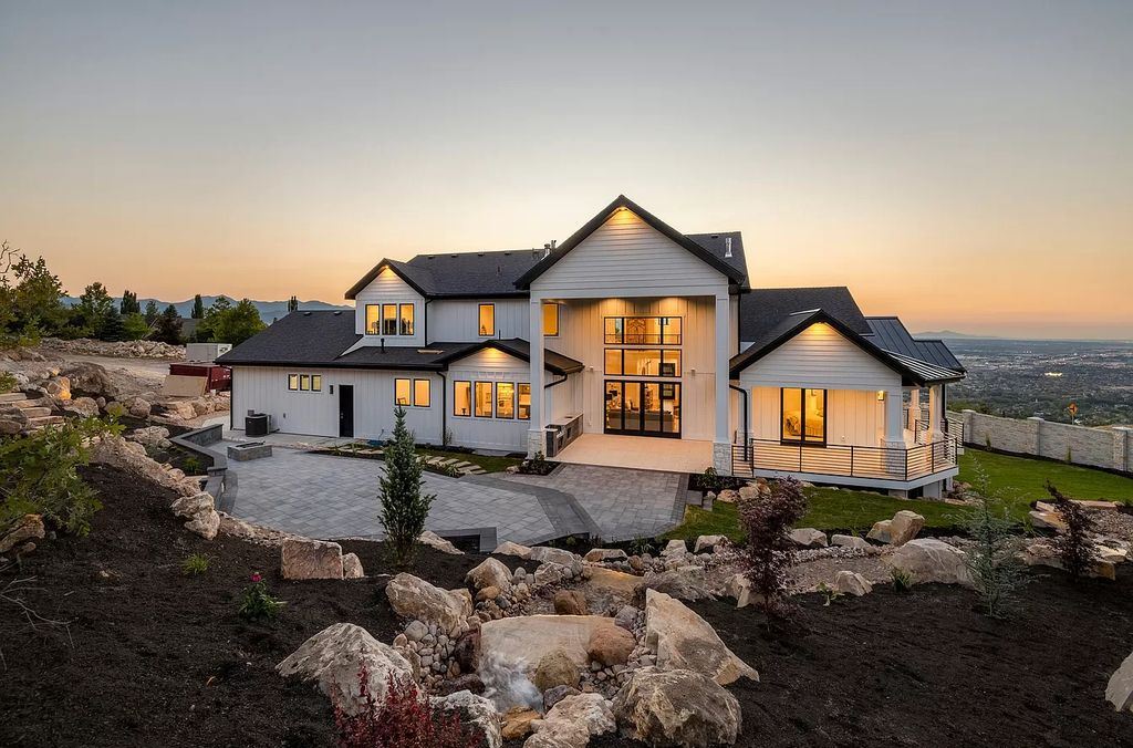 The Modern Farmhouse in Utah is a beautiful newly constructed 2-Story home fully landscaped with a majestic waterfall now available for sale. This home located at 14731 S Aulani Cv E, Draper, Utah; offering 7 bedrooms and 8 bathrooms with over 9,500 square feet of living spaces.