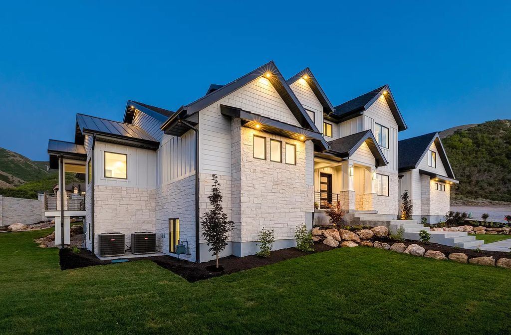 The Modern Farmhouse in Utah is a beautiful newly constructed 2-Story home fully landscaped with a majestic waterfall now available for sale. This home located at 14731 S Aulani Cv E, Draper, Utah; offering 7 bedrooms and 8 bathrooms with over 9,500 square feet of living spaces.