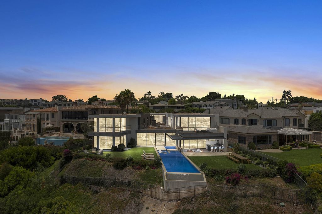 The Home in Newport Beach is a Stunning modern estate boasts unobstructed panoramic ocean, harbor, and city light views now available for sale. This home located at 104 Kings Pl, Newport Beach, California