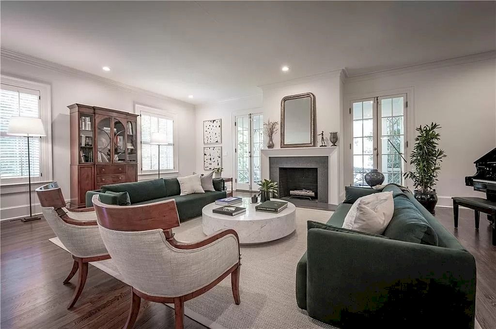 Pick one striking color to brighten up the palette in a living space where neutrals are the norm. Without the addition of green accents, the combination of cream, medium brown, and white in this design of a neutral living room could have come off as uninteresting. A velvet sofa and plants are how the color stands out.