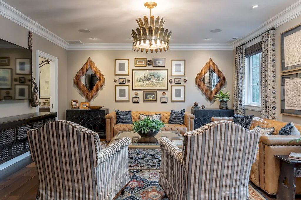 With its magnificent layout, perfect symmetry both vertically and horizontally, and a chandelier that offers just the proper amount of light to the space, this living room is truly in motion. Photographs from various eras, framed in various sizes and patterns, have transformed the wall into an exhibition space. Meanwhile, the rustic and simple sofa style unifies and connects the space. This design also makes use of the trick of having a mirror on the wall to improve the depth of the room.