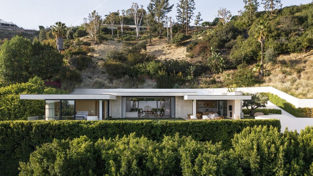 The Modern Mansion in Los Angeles is a warm sophisticated modern home nestled on an acre of land surrounded by lush landscape overlooking LA city now available for sale.