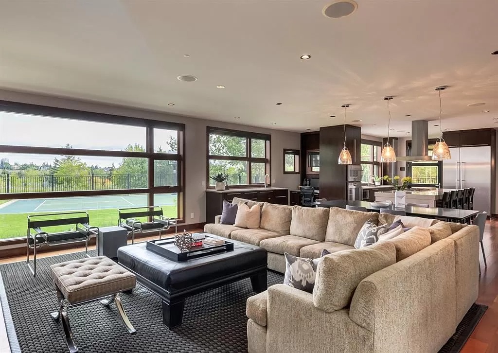 The huge main entrance lets a lot of light into this lovely living area, filling it with light without the use of many electrical gadgets. Because of its tiny cubic designs, a geometric rug gives a neutral yet vibrant backdrop for plain beige fabric furnishings. Not only that, but the rug with a vast area also serves as a barrier between the living room and the adjacent bar, despite the lack of a door or wall.