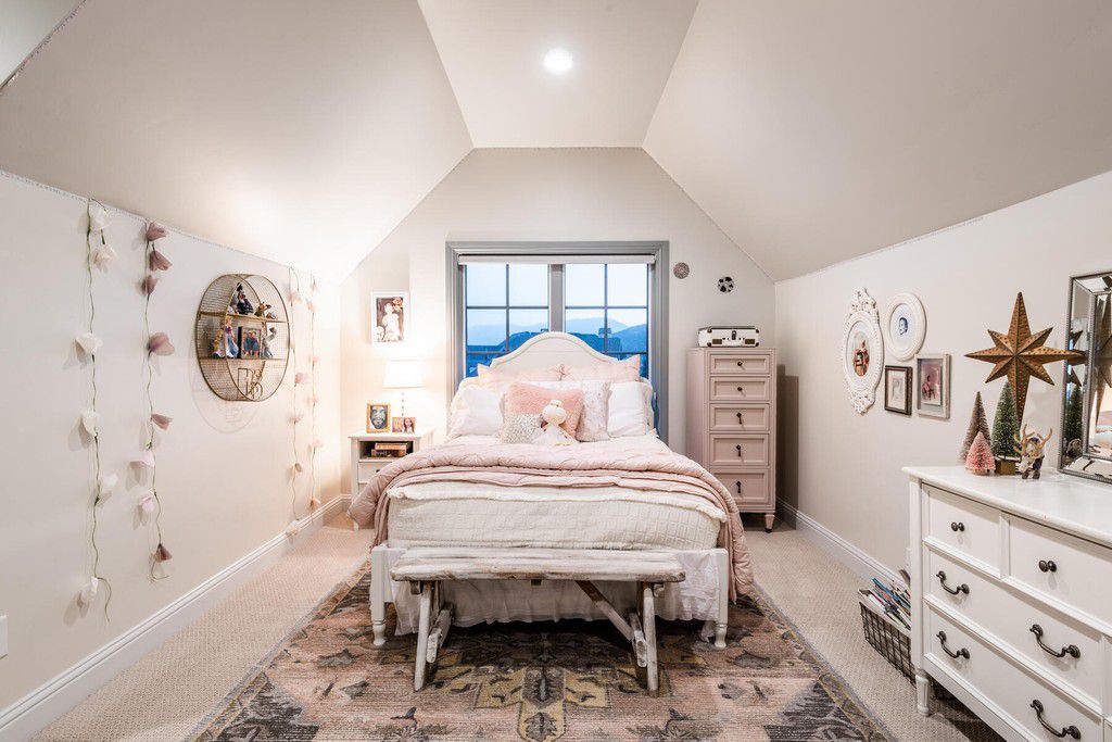 Really, not all that much pink is required to create a pleasant bedroom. You can see how well a few pink accents (like window treatments) and a white accent wall may complement the room's other white furnishings.