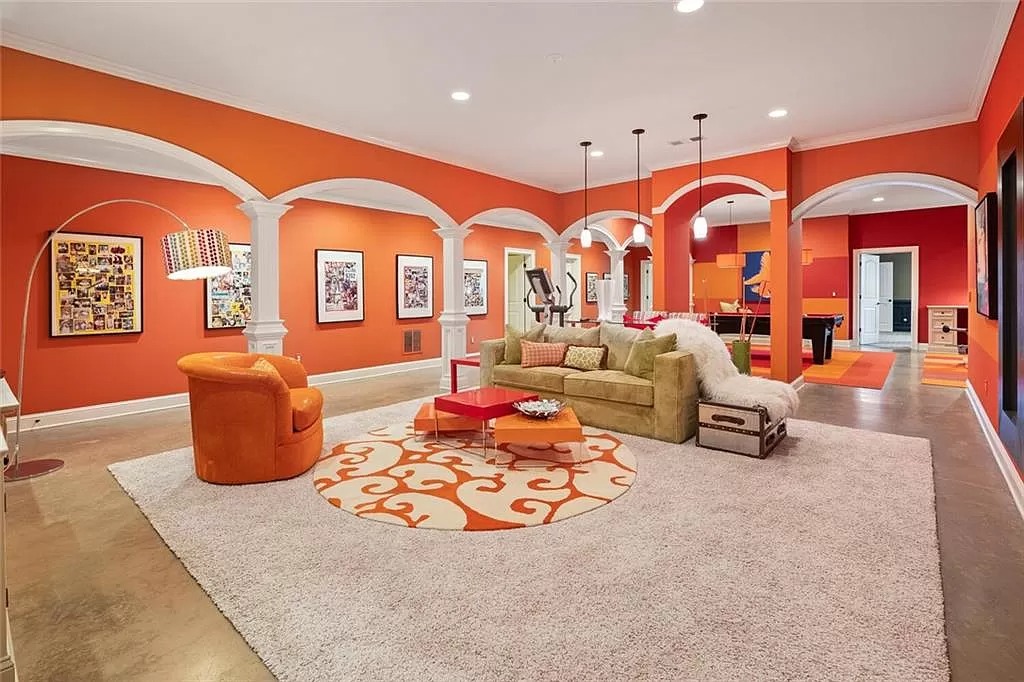 When you walk into this living room, do you envision a gallery? Each small cell on the wall paint with orange and serves as a display area for various artworks. The central area is also outfitted with a sofa set and art-filled tree lights. The playful color palette of orange combined with other tones is also reflected in the back of the room.