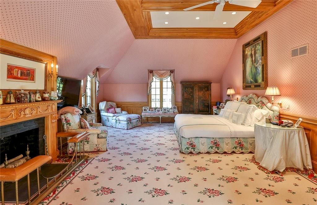 Although the bedding and shades in this bedroom are always a good idea, the space went one step further by upholstering the headboard in the same pattern and extending the wallpaper to the ceiling for a complete pink-out.