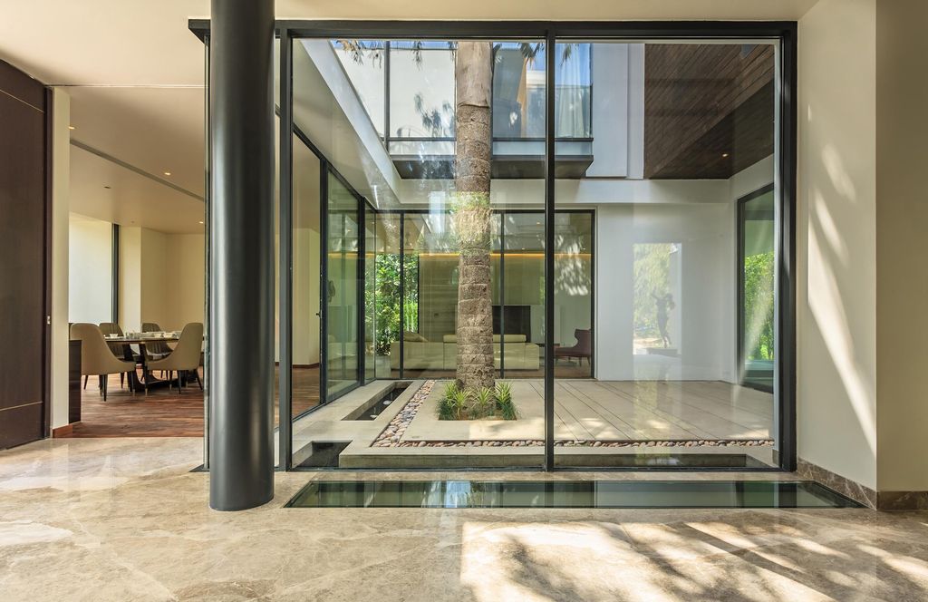 Caryota House, with soaring palm centres modern home by DADA Partners