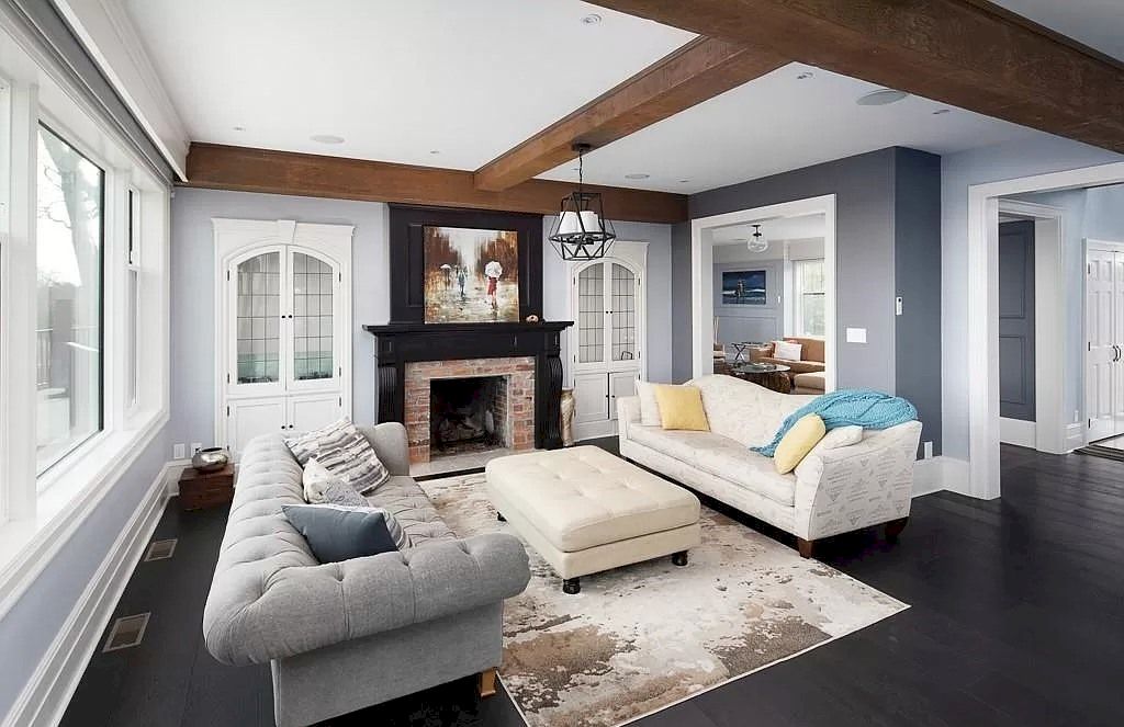 Another mix of three different colors of grey in living room ideas with a grey couch. The majority of the colors are light in tone in order to contrast with the paint on one side of the wall and the wooden beams. A grey sofa, regardless of the material, is always the perfect presence in the living room.