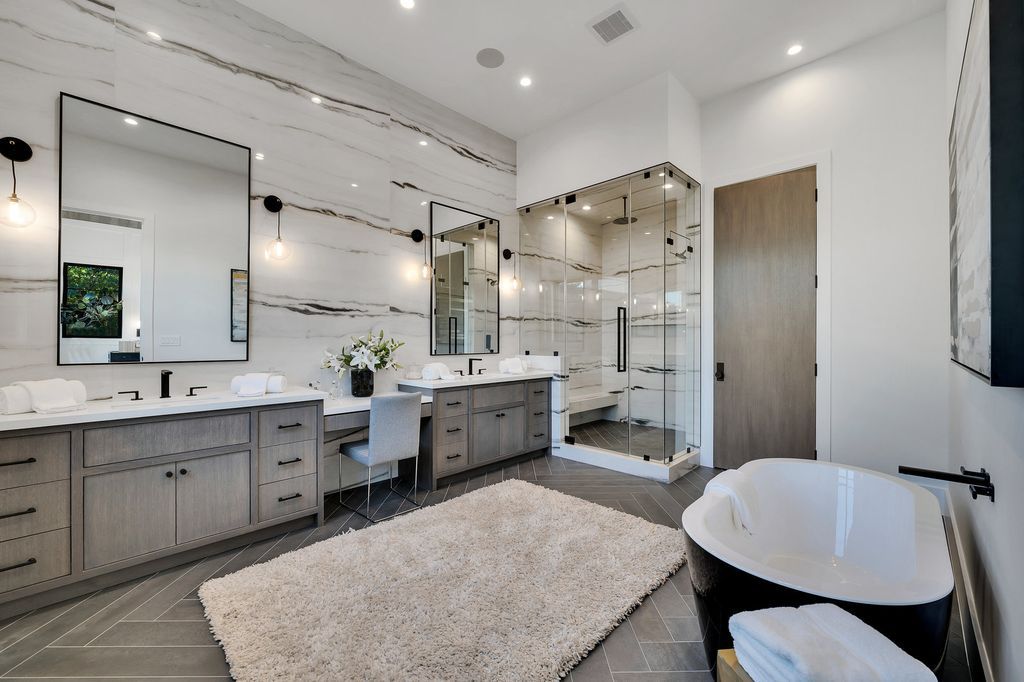 An eye-catching black-and-white bathroom sink backsplash may liven up a plain countertop. Behind the modern vanity, the slim glass liner tiles serve as a practical focal point. To enhance its impact, the backsplash extends from floor to ceiling.