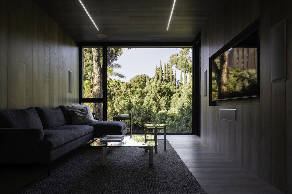 Black window frames, dark gray furniture, and dark hardwood flooring are timeless design elements. This contemporary gray and black living room is sleek and understated, something to look forward to.