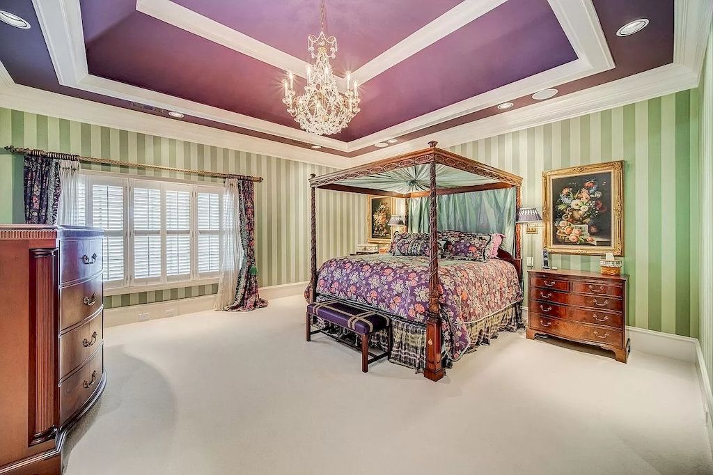 This bedroom will undoubtedly feel fantastic thanks to the addition of fresh flowers, chic purple bedding, and lots of natural light streaming in through old shutters. Wallpaper with a green and white patchwork, though, turns remarkably neutral.