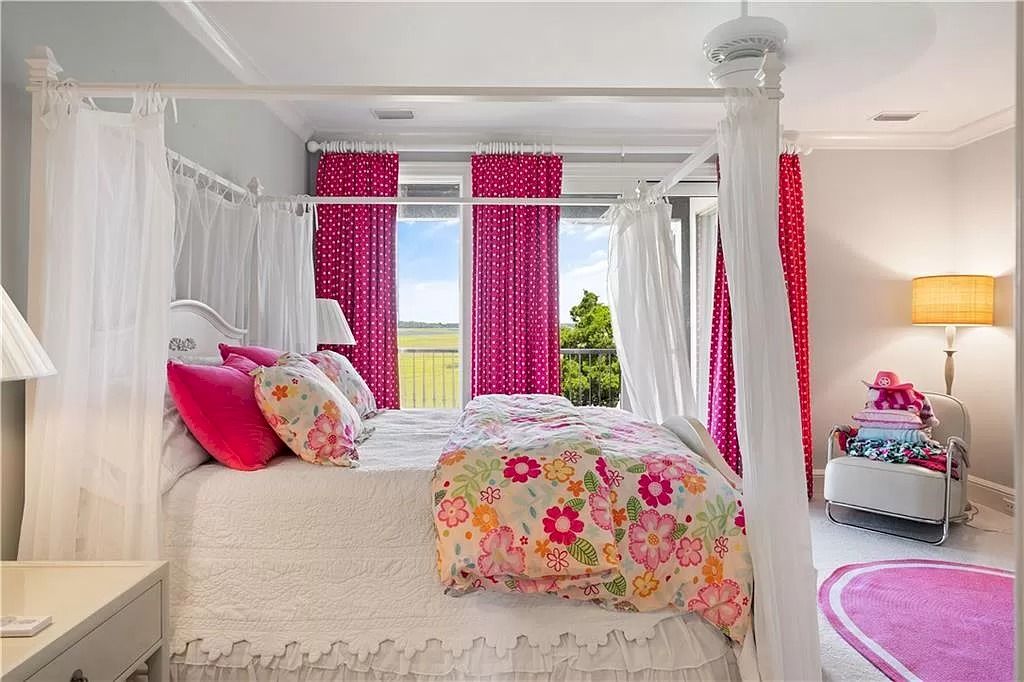 The phrase "eye candy" truly does not do this bedroom justice. The room's brilliant pink color is consistent and forceful throughout, complementing the wall color, bedding, door, and even the gracefully hung pink rug next to the bed.