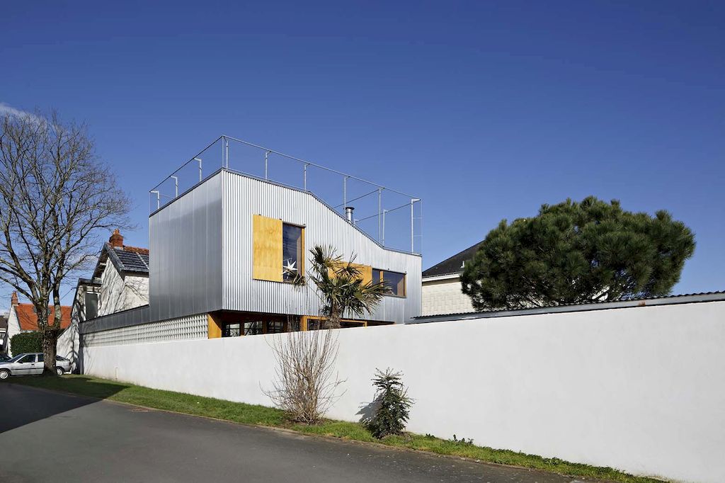 Landscape house features metal wall, sloping roof terrace by Mabire Reich