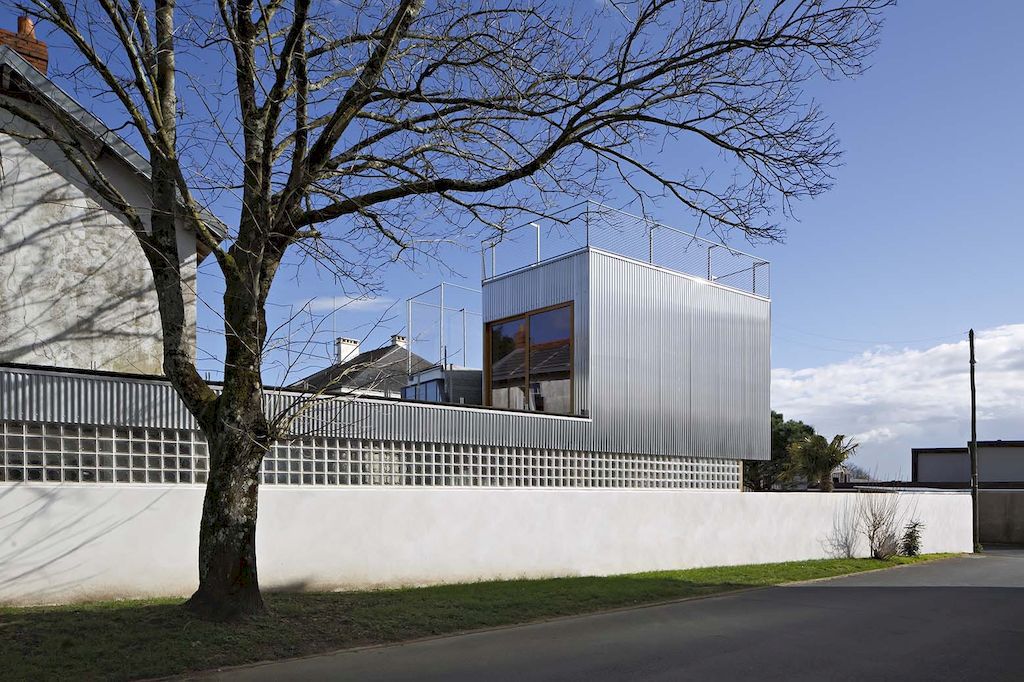 Landscape house features metal wall, sloping roof terrace by Mabire Reich