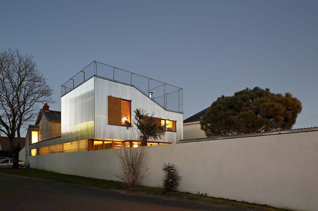 Landscape house features metal wall, sloping roof terrace by Mabire Reich