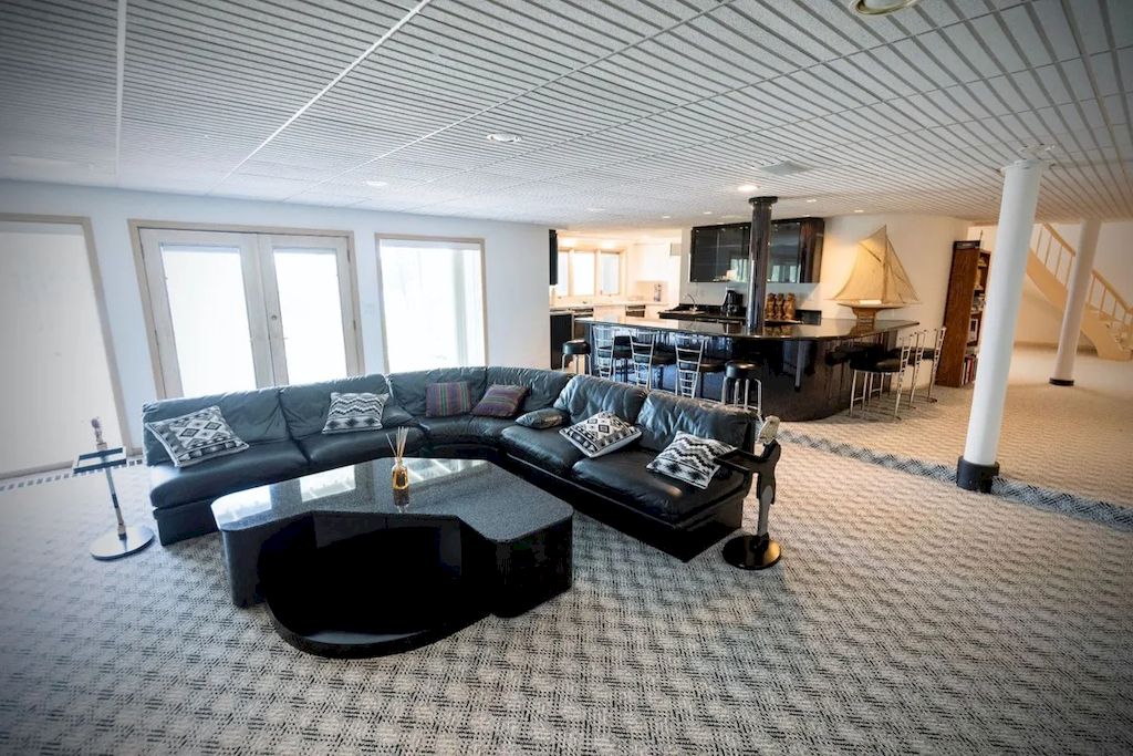 To create cohesion in the space and increase the depth of the room, they used stones with small patterns. To warm the space and match the space frame, the roof has decorative textures from horizontal and vertical stripes. They added a C-shaped beveled table to complement the well-proportioned L-shaped soft leather black couch. Throw on matching black and white pillows with fun wave patterns.