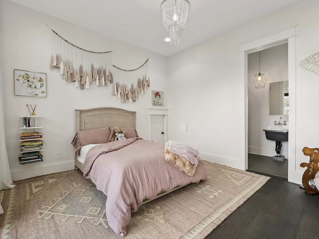 When incorporating pink as a dominant color and striving for a warm bedroom feel, think about a pale tone and pairing it with white for that relaxing impact. The bed frame, throw blanket, and even the carpeting are a subtle shade of pink, while the walls, bedding, and nightstands are still white.