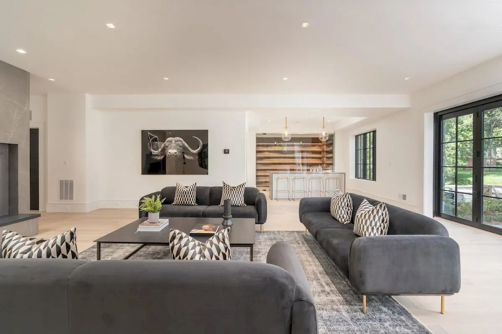 You can use the layout on this design if you need a layout for a huge living area. With the possibility of using many sofas and spreading them evenly throughout the room, a close connection will be created. The mid-century grey sofa set, together with the plain black center table, emphasizes the minimalist aesthetic. The black and white patterned cushions work better in this space.