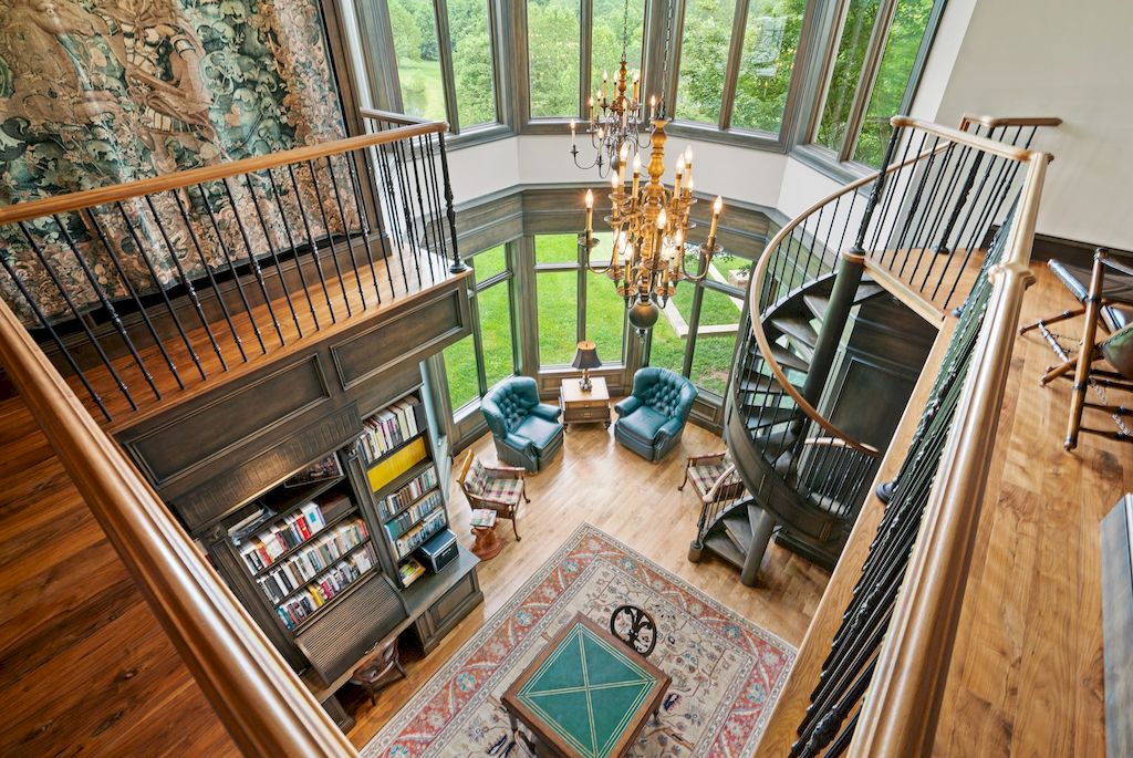 In this stunning location, black and white merge to form an attractive backdrop. The accent wall around the fireplace is painted black with a contrasting white mantle, and the bookcases provide a built-in facade that complements the living room themes. The huge, comfortable white lounge chairs give plenty of sitting, and the Victorian armchair creates a lovely tableau opposite the fireplace. 