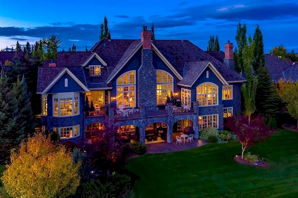 The Magnificent Home in Alberta features extensive hand-hewn grey Canmore limestone, soaring peaks, arched windows, and a majestic sloped roof now available for sale