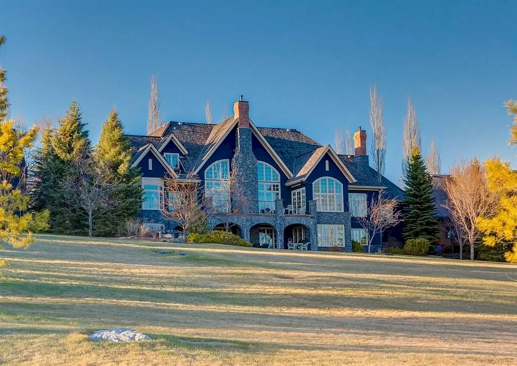 The Magnificent Home in Alberta features extensive hand-hewn grey Canmore limestone, soaring peaks, arched windows, and a majestic sloped roof now available for sale