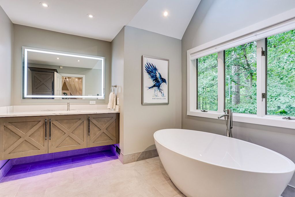 A concrete-inspired hand-plastered backsplash complements a contemporary vanity. This bespoke effect was achieved by troweling gray plaster; a strip of stainless steel beneath the faucets protects against splashes. Combine the material with touches of green for a peaceful blend of earthy and industrial.